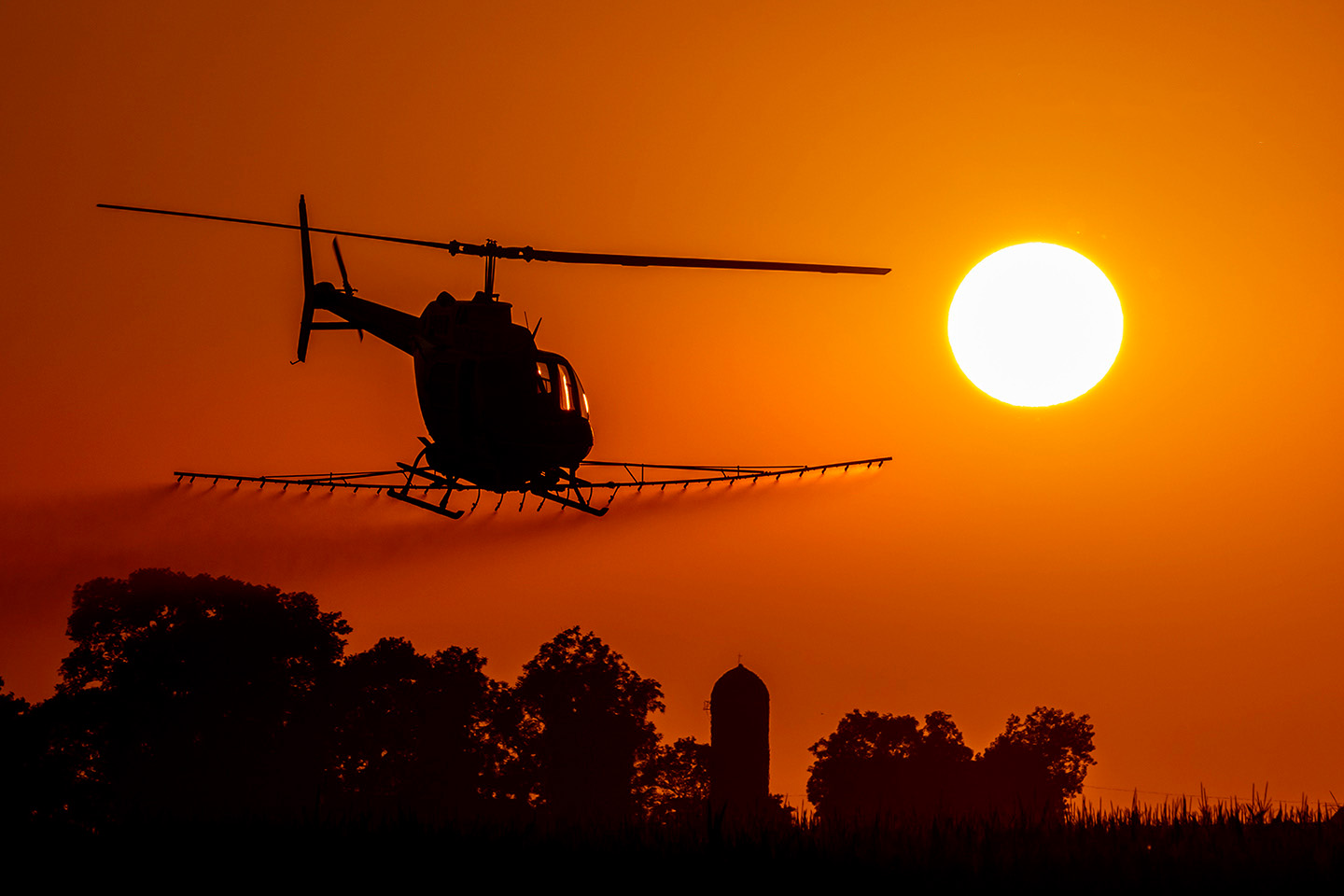 Helicopter sunset crop dusting